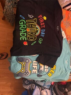 2 size 14 Children's Place t-shirts one black “first day” one green gamer.